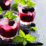 Glass of homemade blackberry juice garnished with fresh mint and blackberries